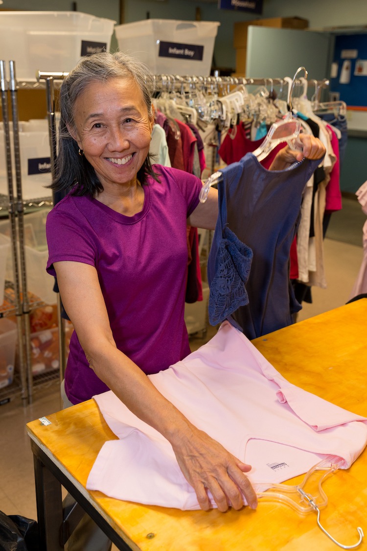ICM Food and Clothing Bank Volunteer Irene Folding Donated Clothes