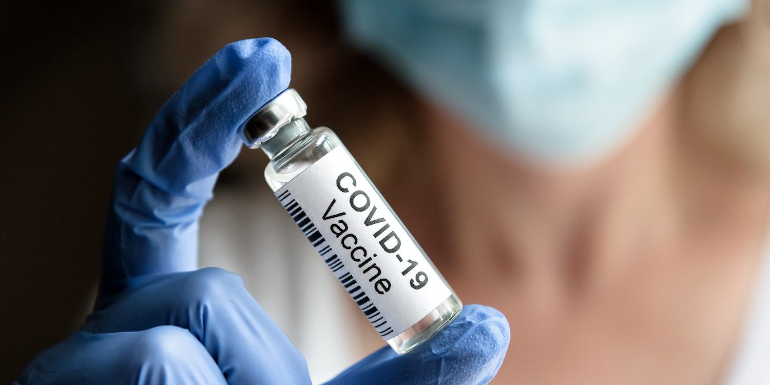 COVID-19 vaccine concept, female doctor holds coronavirus medication in office or laboratory Covid 19 Vaccine Vial at the NourishPhx Free Vaccination Event