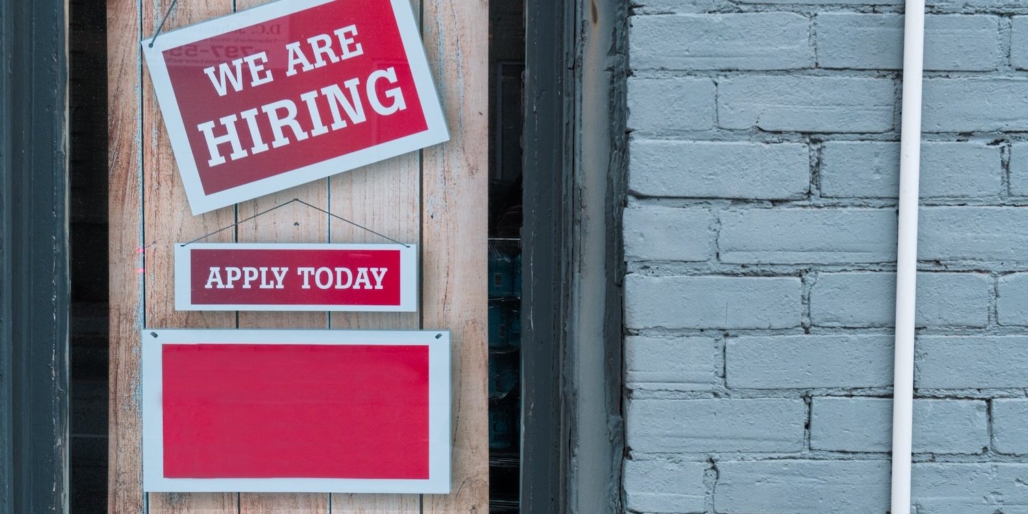 Nourish Phx Now Hiring red sign reading apply today. Program Manager position.